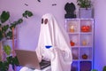 ghost of Halloween uses a laptop to surf the Internet, to browse online stores, markets. ghost makes an order computer