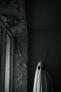 Ghost in a long sheet walking in abandoned home. In a haunted abandoned spooky house. Royalty Free Stock Photo