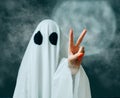 Ghost showing peace gesture in Halloween full moon night.