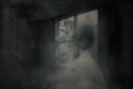 A ghostly, blurred woman in a dress. Looking out of a window in a spooky abandoned house. With a grunge, vintage, old textured