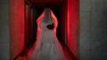 Ghostly figure of woman in wedding dress walking along a creepy hotel in red light. Royalty Free Stock Photo
