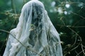 a ghostly figure in the woods with a white veil