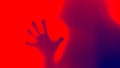 A ghostly hooded figure with a hand coming towards the camera. With a blue, red duo tone edit