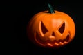 Ghostly isolated plastic Halloween orange pumpkin with scary face