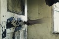 A ghostly transparent hand, holding a door knob. In an old ruined house