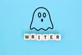 Ghostwriter concept with a ghost symbol and the word writer on wooden blocks against Blue background