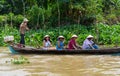 An Giang, Vietnam - Nov 29, 2014: Tourism rowing boat carries tourists wearing Vietnamese conical hat on Tien river, Mekong delta,