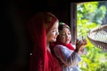 An Giang, Vietnam - Sep 6, 2016: Vietnamese muslim girl wearing traditional red dress playing with her sister in a champa village, Royalty Free Stock Photo