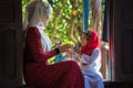 An Giang, Vietnam - Sep 6, 2016: Vietnamese muslim girl wearing traditional red dress playing with her sister in a champa village,