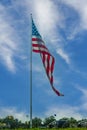 Giant American flag flying over campground under dramatic cloudy blue sky Royalty Free Stock Photo