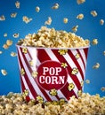 A Giant Bucket of Falling Butter Popcorn on a Blue Background Royalty Free Stock Photo