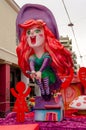 Giant Carnival Float with a Colorful Redhead Witch Riding a Broom. Great Annual Parade with Colored Statues and Funny Float