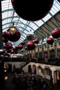 Giant christmas baubles hung from the roof of Covent Garden in London