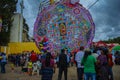 Giant colorful kite with people underneath, made of tissue paper