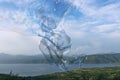 Giant colourful soap bubble twisting in front of lake and mountains Royalty Free Stock Photo