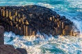 Giant columns of ancient volcanic basalt battered by the ocean waves