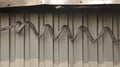 Giant Dirty Spiral Electrical Wire on Corrugated Iron Wall Royalty Free Stock Photo