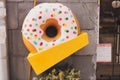 Giant donut sign in front of cafe or restaurant with empty copy space for text or advertising. Fast food and sweet junk