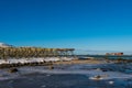 Giant empty wooden racks for hanging and drying cod to make stockfish on the Lofoten islands in Norway on clear winter day snow- Royalty Free Stock Photo