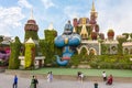 A giant figure of a fairytale genie against the backdrop of a fairytale palace in botanical Dubai Miracle Garden with different