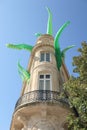 Giant fluorescent green alien tentacles burst out of buildings