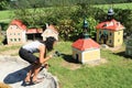 Giant girl taking video of belfry in Minimodel of South Bohemian village