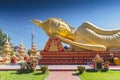 Giant gold reclining sleeping Buddha statue near Wat That Luang Temple, Vientiane, Laos Royalty Free Stock Photo