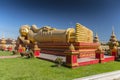 Giant gold reclining sleeping Buddha statue near Wat That Luang Temple, Vientiane, Laos