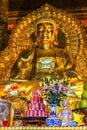 Giant Golden Buddha statue in temple with Coca-Cola offer in fro