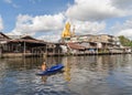 The Giant Golden Buddha in Wat Paknam Phasi Charoen Temple in Phasi Charoen district with boat on Chao Phraya River at noon,