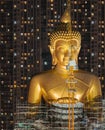 The Giant Golden Buddha in Wat Paknam Phasi Charoen Temple in Phasi Charoen district at night, Bangkok. Urban town, Thailand.