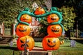 Giant Halloween Jack-o-lantern inflatable archway in front of cute house with funny tombstones and skulls in leafy neighborhood Royalty Free Stock Photo