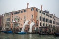 Giant hands rise from the water of the Grand Canal to support th