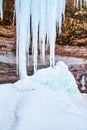 Giant icicles on cliffs forming pile of ice lumps Royalty Free Stock Photo