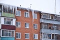 Giant icicles hanging down from the roof of an old residential brick house. Dangerous icicles hangs from the roof. Harsh