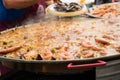 Adding shrimp and shellfish to a giant paella during cooking. Royalty Free Stock Photo