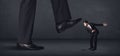 Giant person stepping on a little businessman concept Royalty Free Stock Photo