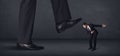 Giant person stepping on a little businessman concept Royalty Free Stock Photo