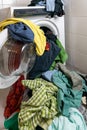 Giant pile of colorful dirty laundry and a washing machine stuffed full with clothes Royalty Free Stock Photo