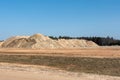 Giant pile of sand against the blue sky. Sand extraction mine.