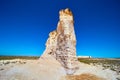 Giant pillar of white rock sticking out of flat desert landscape against blue sky Royalty Free Stock Photo