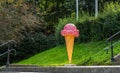 A giant plastic ice cream and cone by an ice cream stand