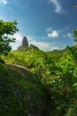 A giant rock against a blue sky with clouds. Royalty Free Stock Photo