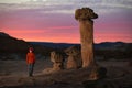 Man hiker by the giant rock toadstools watching sunset in Arizona.