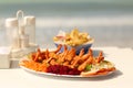 Giant shrimp served with salad and French fries on a beach