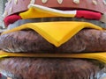 A giant sized model display of a hamburger with cheese