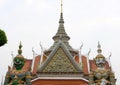 giant statue & sculpture on asian temple. buddhist building encrusted with glazed porcelain tiles & seashell at wat arun