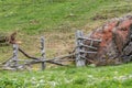 Giant stone boulder on a pasture and destroyed wooden fence, Austria