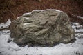 Giant stone in the snow. Natural background with a stone.