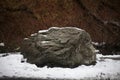 Giant stone in the snow. Natural background with a stone.